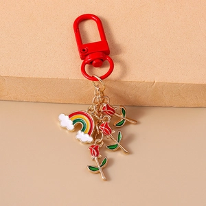 Detail of keychain with red carabiner clasp, rainbow charm, and three red rose pendants