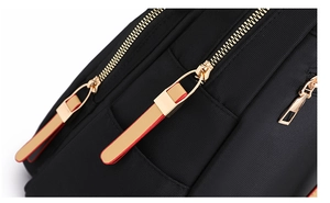 Detailed macro view of durable black oxford fabric and smooth golden metal zipper with strap