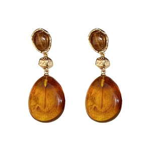 Retro amber resin teardrop earrings with gold metal accents on a white background