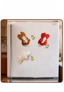 Plush horse magnets in brown, red, and white attached to a refrigerator surface