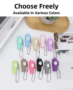 Detailed flat lay of 11 colorful mini cup keychains with daisy decor on a white desk