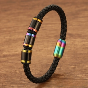 Detail showing braided black leather bracelet with rainbow magnetic clasp on wooden surface