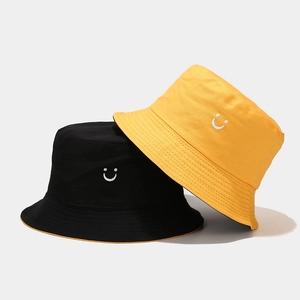 Reversible double-sided cotton bucket hat in black and yellow with smiley face embroidery