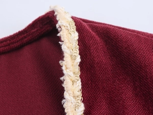 Detail of dark red chenille fabric with premium gold-threaded woven trim on the dress