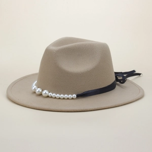 Close-up of beige fedora hat with black ribbon and elegant gradient pearl decoration