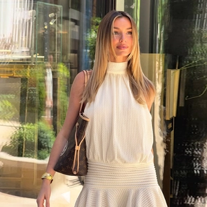 White halter neck sleeveless knitted dress with textured pleats in urban street setting