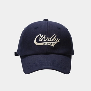 Close-up of vintage navy baseball cap featuring cream 3D embroidery on cotton twill