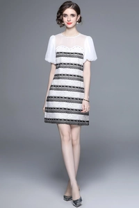 Elegant monochrome dress with lace stripes and sheer puff sleeves on grey background