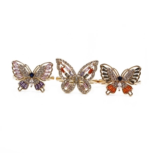 Détail de bagues en cuivre avec papillons en zircone colorée et finition dorée