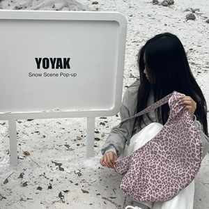 Detail of pink leopard print hobo bag with integrated shoulder strap in a snow setting