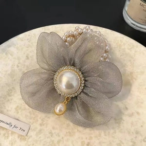 Détail de l'élastique en organza gris avec strass et perle centrale élégante