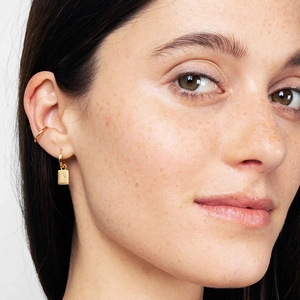 Golden minimalist starburst rectangle drop earrings and ear cuff on female model