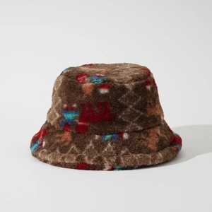 Détail d'un chapeau bob en fausse fourrure marron avec des motifs géométriques colorés