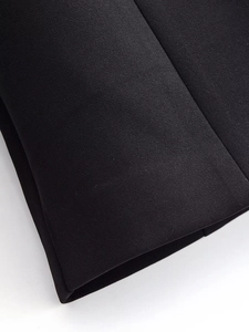 Détail du tissu d'un costume noir montrant les coutures de qualité et la texture tissée