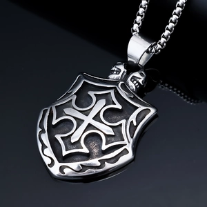 Macro detail of gothic cross shield pendant with skull accents on a box chain