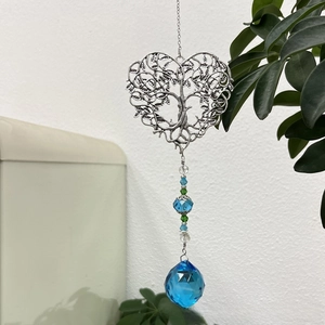 Detail of a heart tree of life crystal suncatcher with blue beads and a crystal ball
