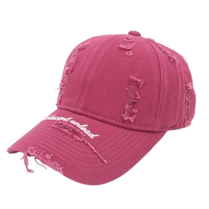 Detail of frayed edge and white letter embroidery on a rose pink washed baseball cap