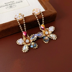 Macro detail of vintage floral drop earrings with pearls and colorful crystals