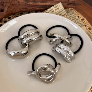 Detail of silver geometric hair ties set showing hammered and twisted metal textures