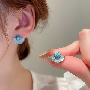 Detailed view of vintage bohemian fan-shaped stud earrings with turquoise stone inlay