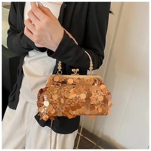 Detail shot of a sparkling gold sequin evening bag with a metallic top handle and chain strap