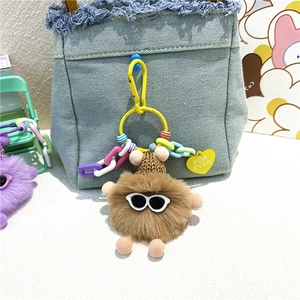 Porte-clés monstre en peluche marron avec lunettes de soleil sur sac en jean
