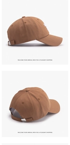 Détail d'une casquette marron avec broderie de lettres blanches et boucle métallique réglable