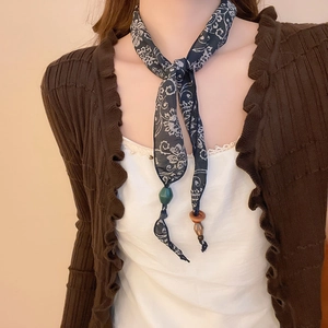 Detail of dark blue paisley silk scarf with green resin beads and wood pendant accents