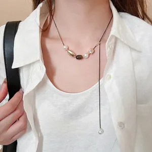 Tiger eye and pearl flower pendant necklace on a model with white linen shirt
