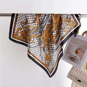 Detail of luxury silk square scarf with golden buckle and chain patterns on metal hanger