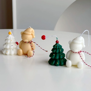 Detailed view of handmade mini Christmas tree and bear candles for festive home decor