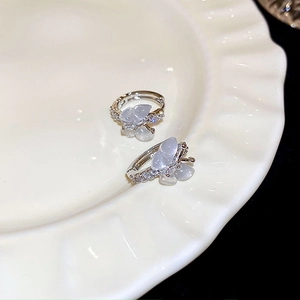 Détail macro de boucles d'oreilles papillon avec cristaux et base en argent sur plateau