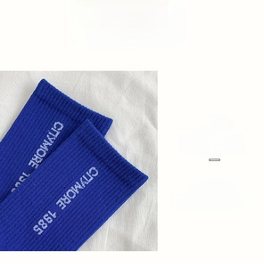 Detail of high-elasticity ribbed cuff on blue crew socks with white lettering