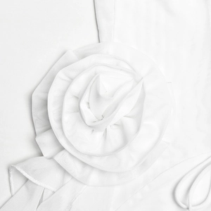 Detailed macro view of an elegant white mesh 3D flower decoration on a dress