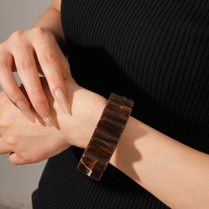 Macro shot of wide tortoise shell resin bangle with amber textured block segments