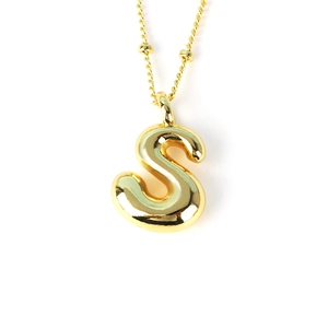 Macro view of golden bubble letter S pendant with shiny metallic 3D rounded finish