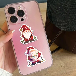 Waterproof Christmas gnome stickers applied on a pink phone case with holiday light motifs