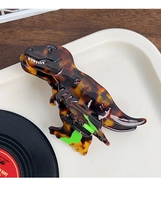 Detailed view of a tortoiseshell acetate dinosaur hair claw clip with green spring mechanism