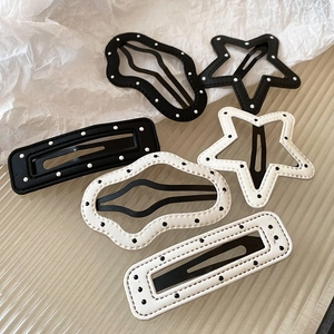 Detailed view of polka dot star and wave hair clips with elegant stitched leather edges