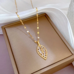 Elegant gold-plated leaf necklace with micro-paved zircons on a white silk background