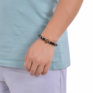 Detailed view of 8mm tiger eye and faceted black stone beaded bracelet on wrist