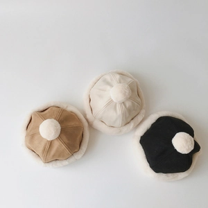 Detailed view of winter suede beanies with faux fur trim in brown, cream, and black