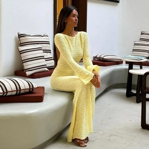 Détail d'une robe longue jaune clair avec un élégant dos nu et des manches longues évasées
