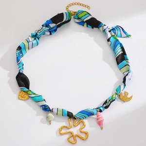 Détail du collier ruban de soie coloré avec breloques dorées et perles de coquillage