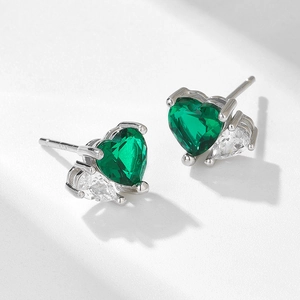 Detailed macro of S925 silver stud earrings with heart-shaped green emerald zircon stones