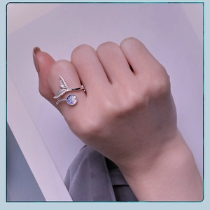 Detail of s925 silver fishtail ring with colorful scales and diamonds on a finger