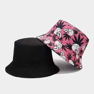 Close-up of reversible bucket hat with pink skull and leaf print alongside a black version