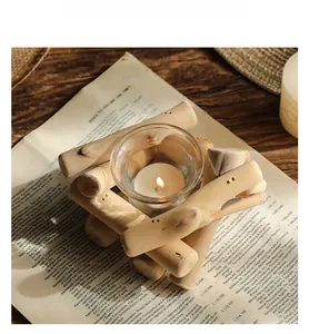 Detalle de un portavelas rústico de madera con vidrio y una vela de té encendida
