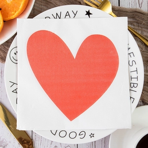 Detail shot of white square napkin featuring a large red heart print for Valentine's Day