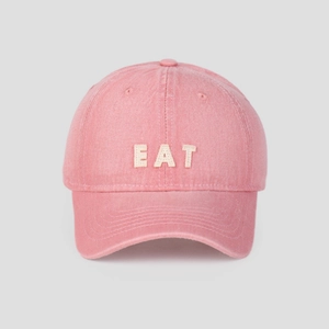 Detail of pink washed cotton baseball cap with white EAT 3D embroidery and ventilation holes